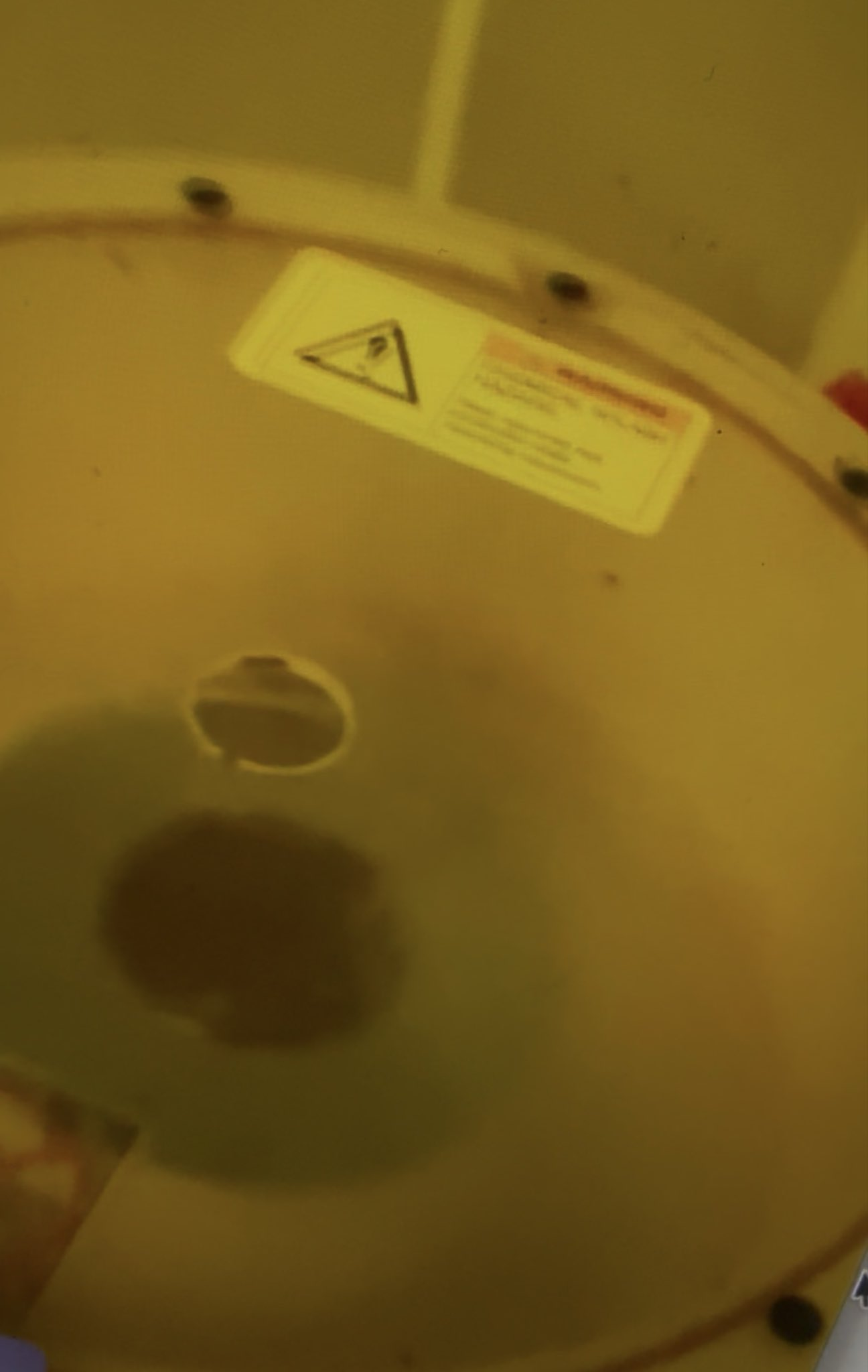 A close-up from the fabrication environment, seen through an amber-toned cover.