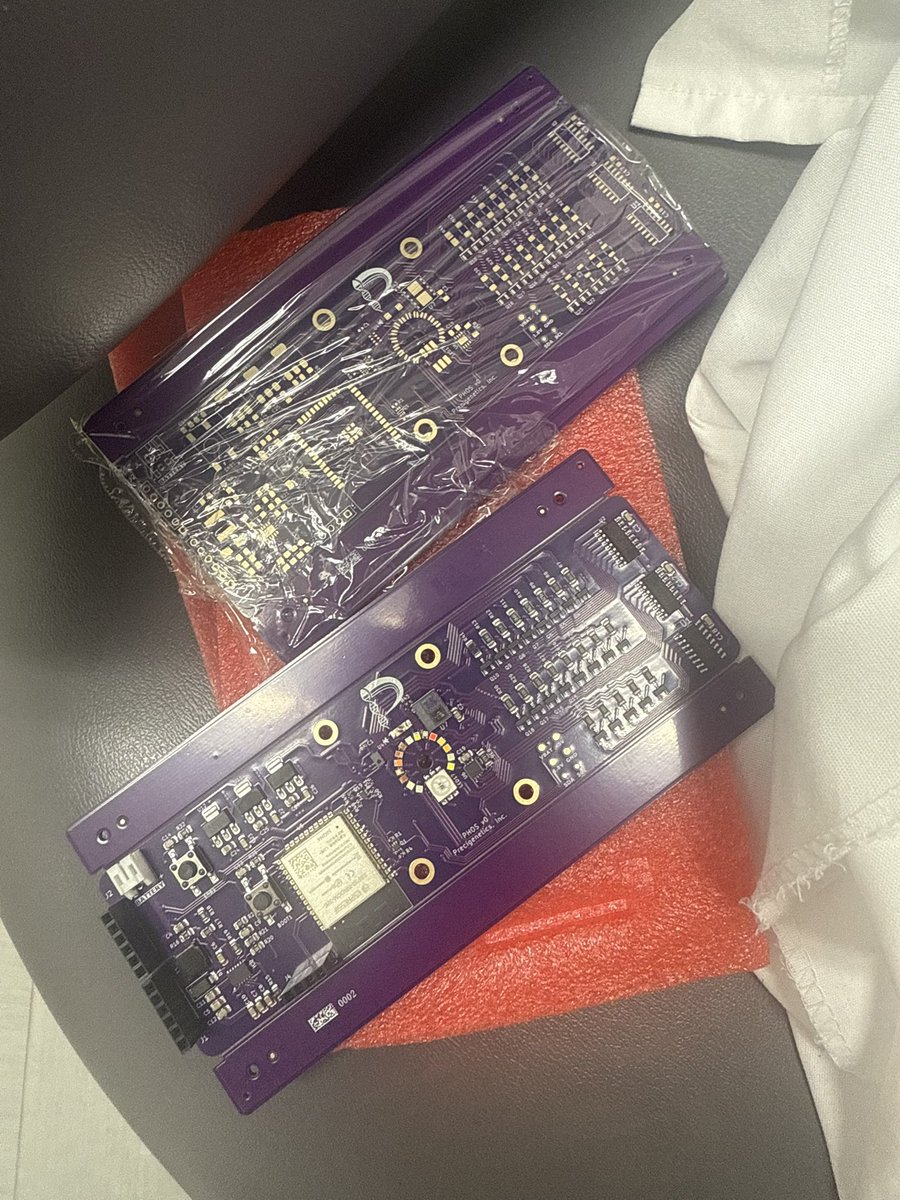 Two purple Phos v0 circuit boards carrying the Precigenetics logo.